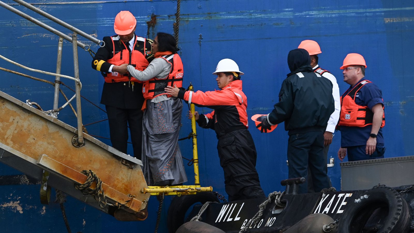 Personnel transferring between a crew boat and a ship at the foot of the accommodation ladder